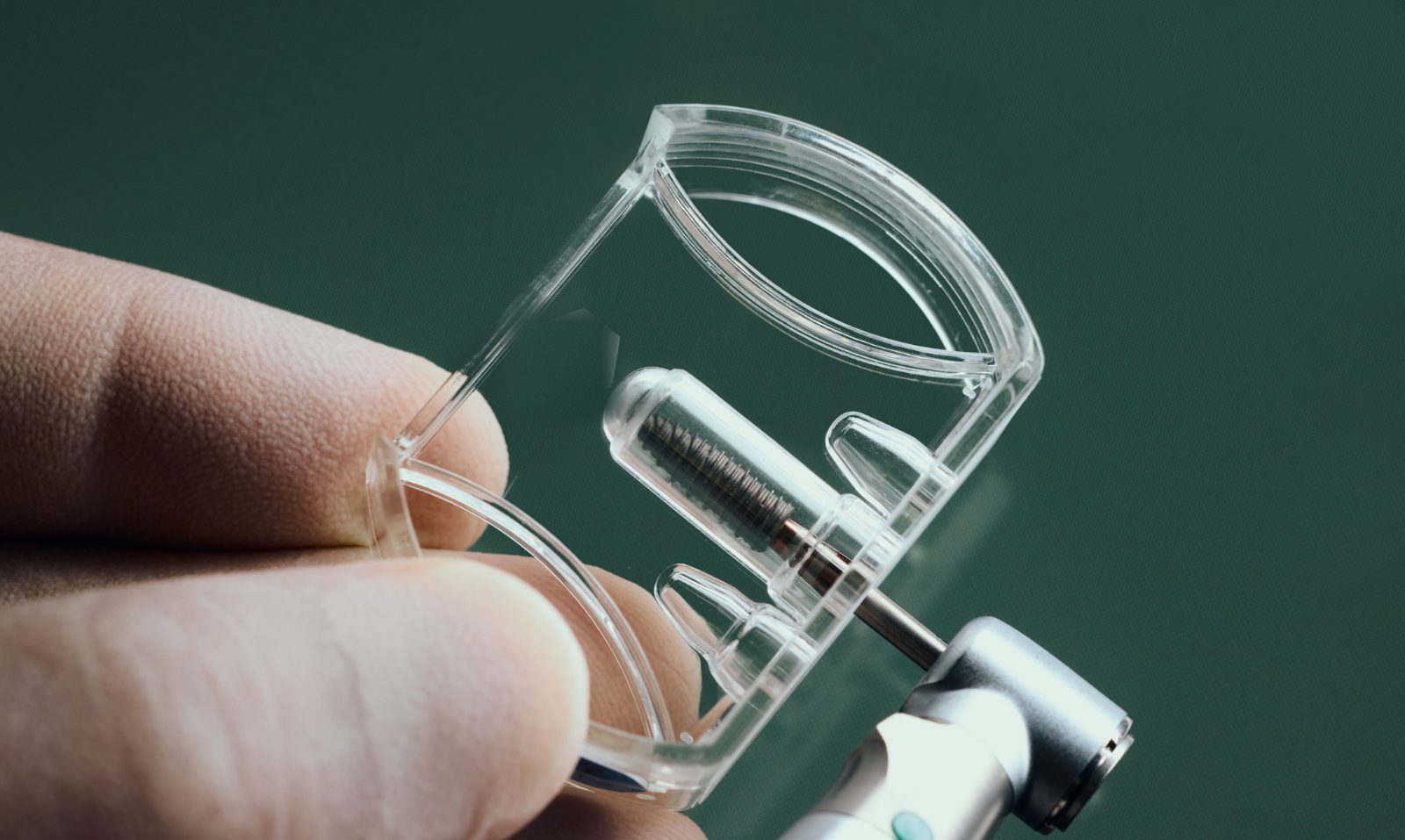 Implant dentaire en titane dans son conditionnement stérile, tenu à la main