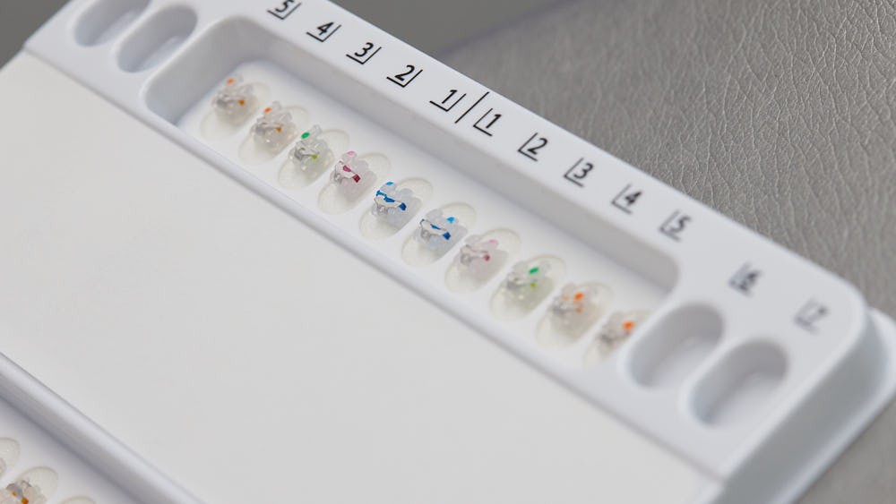 Attaches céramiques rangées par dent sur leur plateau